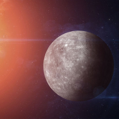 Heavily cratered grey-brown planet partially illuminated by a star in an astrology article