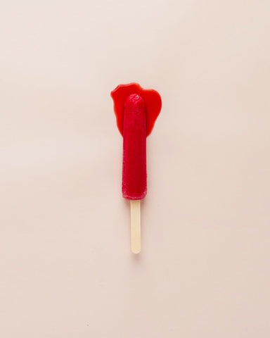 Melting red popsicle on a stick in an article about hormones and mental health