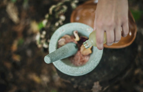 Mortar and pestle with fresh ingredients for herbal preparation in a wellness practice