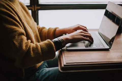 Person typing on a silver Laptop for relaxation in the How to Unwind After a Busy Day article