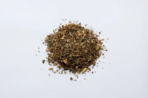 Pile of dried crushed herbs with green and brown fragments for Root Chakra support