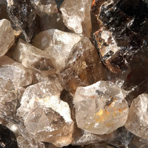Pile of rough natural smoky quartz crystals for balance and grounding in healing