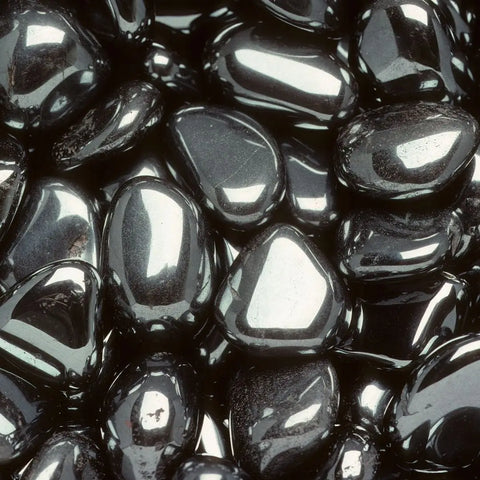 Pile of polished hematite stones symbolizing grounding and balance in crystal healing