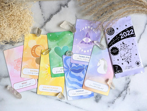 Colorful chakra-themed oracle cards with celestial and symbolic designs for spiritual guidance