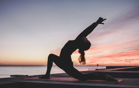 Silhouette of person in yoga pose at sunset for Yes its Hormones article