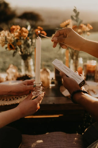 Tall white candle in clear glass candlestick symbolizing spiritual connection and intuition