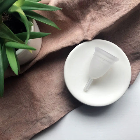 Translucent silicone menstrual cup with stem featured in Yes its Hormones No Youre Not Crazy article