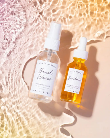 Two skincare bottles, a clear spray and yellow oil, for natural hair rejuvenation