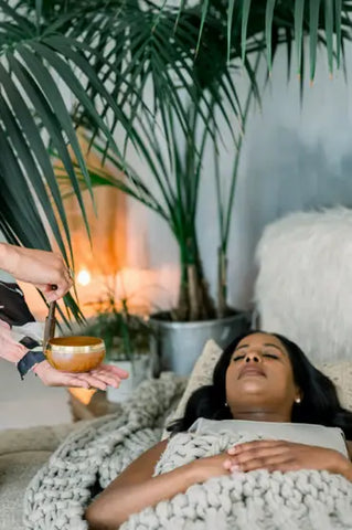 Woman receiving a sound bath treatment for relaxation and lucid dreaming