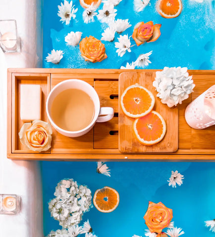 Wooden bath caddy with cup soap flower and orange slices for relaxing bath time