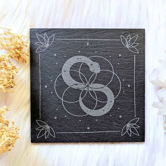 Infinite Magic Altar Tile with a serpent image in the centre and flowers in the corners  on a cloth background. Available at Goddess Provisions