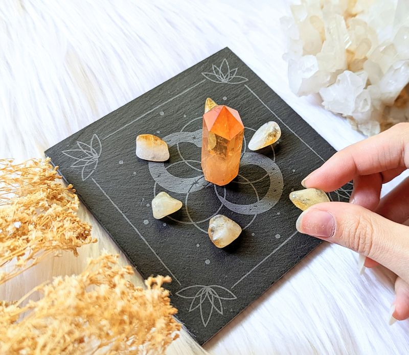 Infinite Magic Altar with a hand placing crystals on tile. Altar tools available at Goddess Provisions.