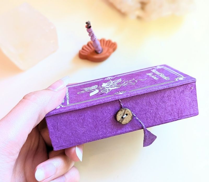 Stupa Smoke Rope Incense and womans hand holding the box. Available at Goddess Provisions