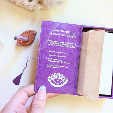 Stupa Smoke Rope Incense with product description inside box and woman's hand holding the box open