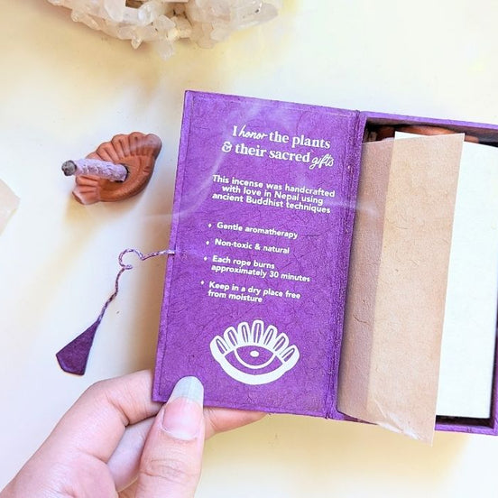 Stupa Smoke Rope Incense with product description inside box and woman's hand holding the box open