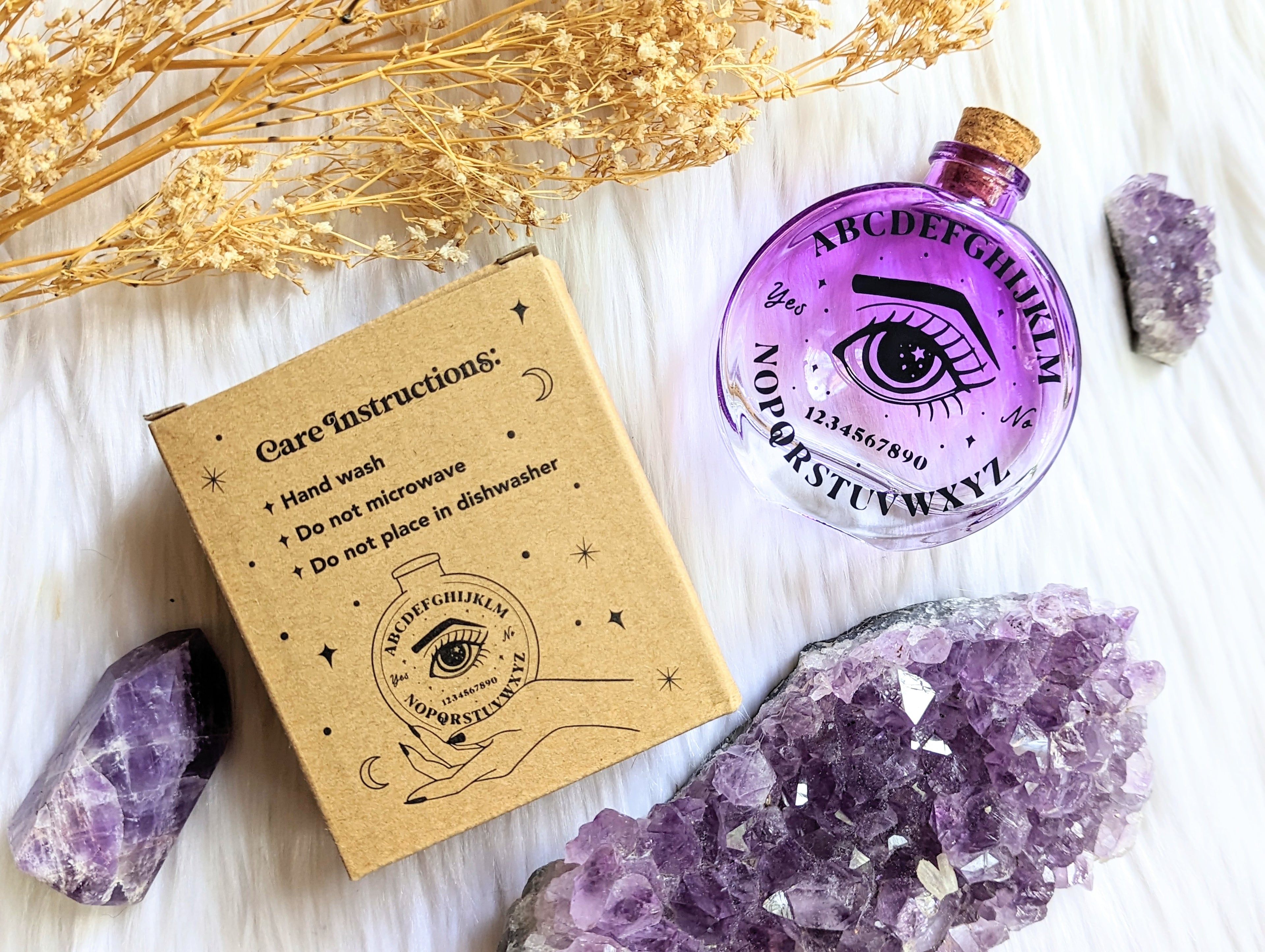 Cosmic Answers Glass Potion Bottle with packaging and crystals. Available at Goddess Provisions. Ideal for rituals, your altar, potions, and spellwork.