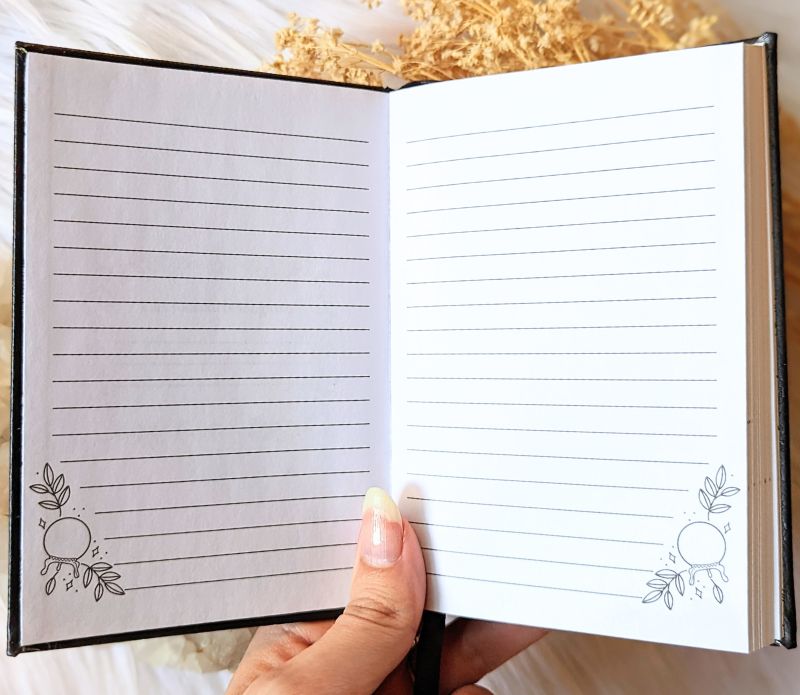 A5 celestial journal made from recycled paper, with 120 lined pages and embossed moon phases design on black vegan leather. Perfect for magical moments and daily to-dos.
