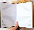A5 celestial journal made from recycled paper, with 120 lined pages and embossed moon phases design on black vegan leather. Perfect for magical moments and daily to-dos.