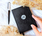 A5 celestial journal made from recycled paper, with 120 lined pages and embossed moon phases design on black vegan leather. Perfect for magical moments and daily to-dos.