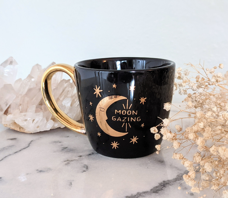Black and celestial ceramic mug with moon and sun design available at Goddess Provisions